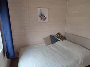sypialnia z białym łóżkiem w pokoju w obiekcie WIDOKI Rusinowo Domki Letniskowe w mieście Rusinowo