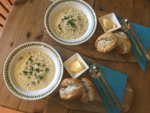 a table with two bowls of soup and some bread at Nether Dallachy Farmhouse in Banff