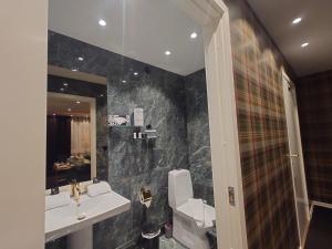 a bathroom with a sink and a toilet and a mirror at Palace Hotell in Hultsfred