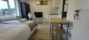 Schlafzimmer mit einem Bett, einem Tisch und einem Schreibtisch in der Unterkunft Stylish Home from Home in Orpington