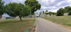 una vecchia casa in pietra su una strada in un campo di Cute Apartment Marla Art close to Center a Pola (Pula)