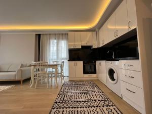 a kitchen with white cabinets and a table with a couch at PURPLE VIP SUITE in Trabzon