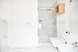 a white bathroom with a shower and a sink at MILANO URBAN FLATS Modern apartments few minuts from Duomo in Milan