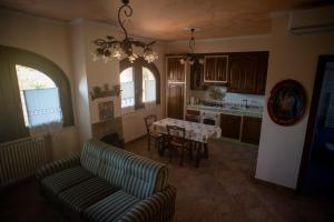 a living room with a table and a couch and a kitchen at La Ginestra in Castel San Lorenzo