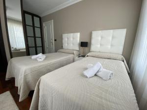 a room with two beds with towels on them at Villa OLYMPIA in Castro-Urdiales