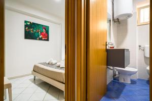Habitación con baño con cama y aseo. en Loft Baia di Letojanni, en Letojanni