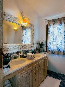 La salle de bains est pourvue d'un lavabo et d'un miroir. dans l'établissement Sardinian Luxury Hospitality - Villa Fuli Rooms and more, à Golfo Aranci