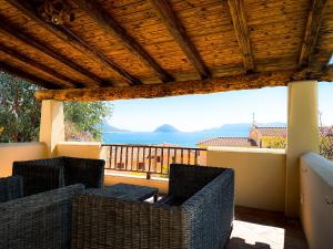 Sardinian Luxury Hospitality - Villa Fuli Rooms and more في غولفو أرانتْشي: شرفة مع كراسي وإطلالة على المحيط