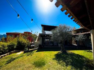 Sardinian Luxury Hospitality - Villa Fuli Rooms and more في غولفو أرانتْشي: منزل به ساحة مع شجرة