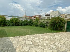 a yard with a stone walkway in a city at Guesthouse Niko in Berat