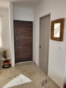 einen Flur mit einer Tür und einem Spiegel an der Wand in der Unterkunft Maison Playa in Playa del Carmen