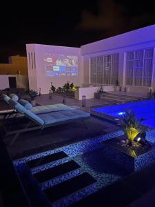 a swimming pool with blue lights in front of a building at JHR chalet in Salalah