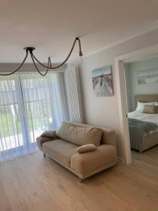 sala de estar con sofá y cama en Three By The Sea apartments at Albatross Home, en Ķesterciems