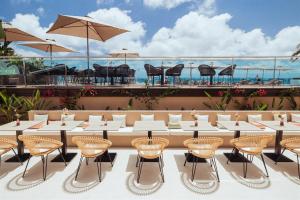 una fila de mesas y sillas en un patio en AMA Ibiza en Playa d'en Bossa