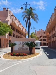 un cartel para un hotel en una calle con palmeras en La Isla Casa de Franco - Condado De Alhama Golf Course, en Alhama de Murcia