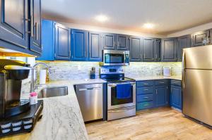 una cucina con armadi blu ed elettrodomestici in acciaio inossidabile di Waterfront Home with Views and Dock in Sunrise Beach! a Sunrise Beach