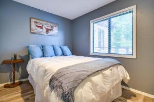 una camera da letto con un letto con cuscini blu e una finestra di Waterfront Home with Views and Dock in Sunrise Beach! a Sunrise Beach Altre 25 foto