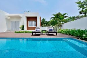 uma villa com uma piscina, uma mesa e cadeiras em Four Points by Sheraton Mahabalipuram Resort & Convention Center em Mahabalipuram