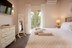 a bedroom with a large white bed with a window at Villa Del Monte in Arménoi