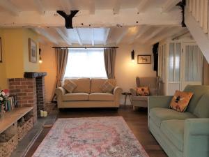 una sala de estar con 2 sofás y una ventana en Cruck Cottage, en Pickering