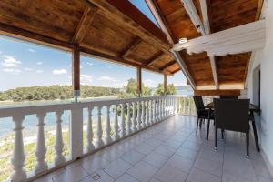 a dining room with a balcony with views of the water at Villa Rosmarin in Pašman