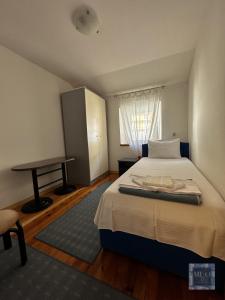 ein Schlafzimmer mit einem großen Bett und einem Tisch in der Unterkunft Muo 33 Apartments in Kotor