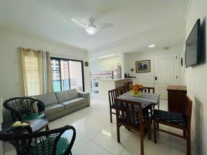 - un salon avec un canapé, une table et des chaises dans l'établissement 6 Flats Capitania Varan, Pitangueiras, wifi, à Guarujá