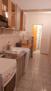 a kitchen with white appliances and a tile floor at Apartments Duce (122) in Duće