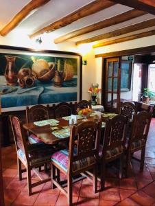 a dining room with a table and chairs and a painting at Hotel Villa Cristina in Villa de Leyva