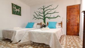 2 camas en una habitación con un árbol en la pared en Casa rural mirador de sole en Cazorla