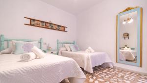 Un dormitorio con dos camas y un espejo. en Casa rural mirador de sole, en Cazorla 6 fotos más