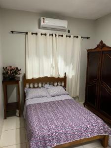 1 Schlafzimmer mit einem Bett und Klimaanlage in der Unterkunft Suítes privadas em casa espaçosa in Rio Verde