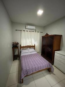 ein Schlafzimmer mit einem Bett und einer Kommode in der Unterkunft Suítes privadas em casa espaçosa in Rio Verde