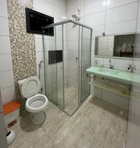 ein Badezimmer mit Dusche, Toilette und Waschbecken in der Unterkunft Suítes privadas em casa espaçosa in Rio Verde