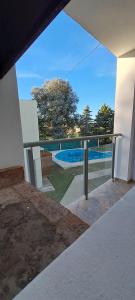 una vista sulla piscina dal balcone di una casa di Departamento Temporario - Barrio San Isidro (Malibu) a Villa Allende