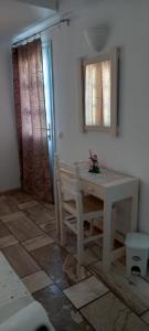 a white table and chairs in a room at Dimitris Studios in Perissa