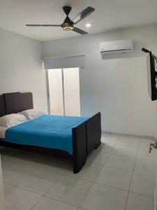 Schlafzimmer mit einem Bett und einem Deckenventilator in der Unterkunft Hermosa casa en Costa de Oro in Montería