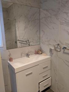 La salle de bains est pourvue d'un lavabo blanc et d'un miroir. dans l'établissement Country Lane, à Horningsea Park