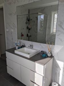 un bagno con un lavandino bianco e uno specchio di Country Lane a Denham Court Altre 5 foto