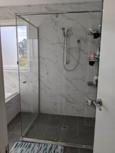 La salle de bains est pourvue d'une douche avec une porte en verre. dans l'établissement Country Lane, à Horningsea Park