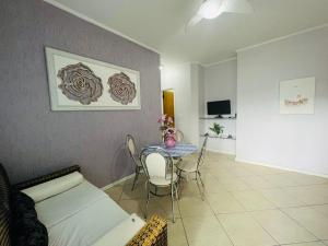 - un salon avec une table et un canapé dans l'établissement 1 Flats Capitania Varan, Wifi, Pitangueiras vista ao mar, à Guarujá