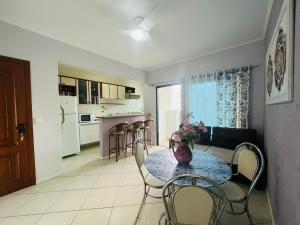 Il comprend un salon avec une table et des chaises ainsi qu'une cuisine. dans l'établissement 1 Flats Capitania Varan, Wifi, Pitangueiras vista ao mar, à Guarujá