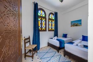 a bedroom with a bed and a chair and a door at Riad SULTANA in Tangier