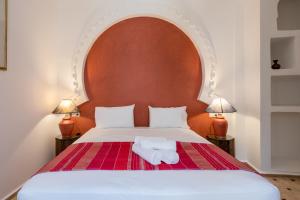 a bed with two towels sitting on top of it at Riad SULTANA in Tangier