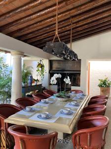 a dining room with a long table and red chairs at Casa Don Pancho in Cuernavaca