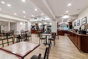 a restaurant with tables and chairs and a bar at Best Western Plus Brunswick Bath in Brunswick