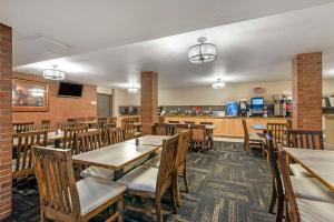 a restaurant with wooden tables and chairs and a bar at Best Western Plus Rio Grande Inn in Durango