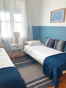 2 Betten in einem blau-weißen Zimmer in der Unterkunft Cozy 3 room apartment near House of Music in Porto