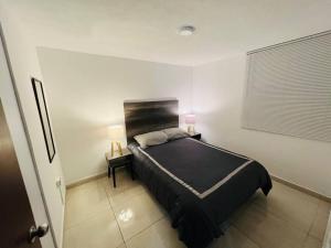 een slaapkamer met een bed en twee lampen op een tafel bij Hermoso departamento a dos cuadras de Col. Roma in Mexico-Stad