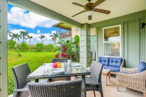 a patio with a table with chairs and a ceiling fan at Pili Mai 1A in Koloa